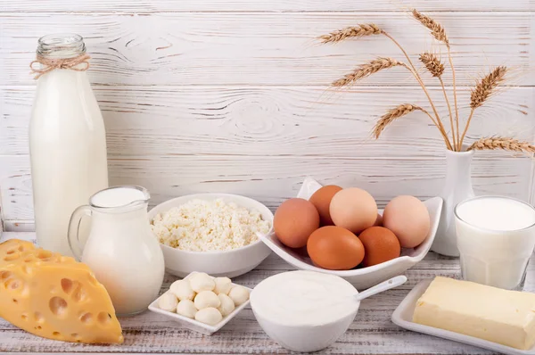 Productos lácteos sobre mesa de madera. Leche, crema agria, queso, huevo, yogur y mantequilla. Comida saludable, concepto de dieta —  Fotos de Stock