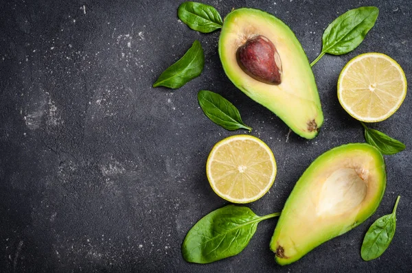 Avocado mit Blattspinat und Limette auf dunklem Betongrund — Stockfoto