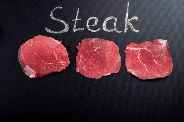 Rauw vlees. Rauwe biefstuk op blackboard — Stockfoto