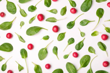 Ispanak yaprakları ve beyaz arka plan üzerinde turp. Ispanak ve izole sebze desen. Yaratıcı yiyecekler kavramı. Salata için madde. Düz yatıyordu