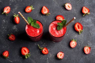 Çilek güler yüzlü veya milkshake cam siyah arka plan üzerine. Kahvaltı ve yemek için sağlıklı gıda. Diyet ve detoks kavramı