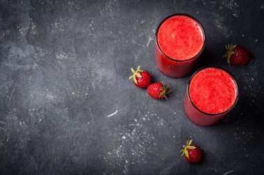 Çilek güler yüzlü veya milkshake cam siyah arka plan üzerine. Kahvaltı ve yemek için sağlıklı gıda. Diyet ve detoks kavramı