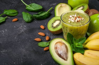 Sağlıklı yeşil smoothie ve malzemelerin koyu arka plan üzerine. Kivi smoothie meyve ile. Superfoods, diyet, Detoks, sağlık, vejetaryen yemek
