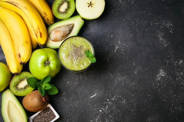 Frullato verde sano e ingredienti su sfondo scuro. Frullato di kiwi con frutta e semi di chia. Superfoods, dieta, disintossicazione, salute, cibo vegetariano — Foto Stock