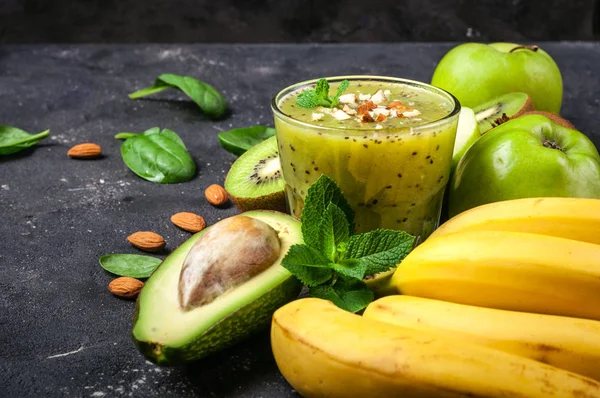 Smoothie desintoxicante saludable con kiwi, aguacate, plátano, manzana y espinacas. Batido verde sobre fondo gris. Alimentación y dieta saludables — Foto de Stock
