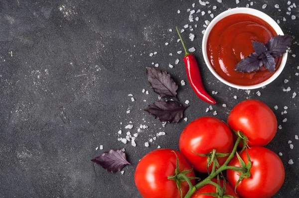 Salsa de ketchup de tomate en un bol con albahaca y tomates. Vista superior —  Fotos de Stock