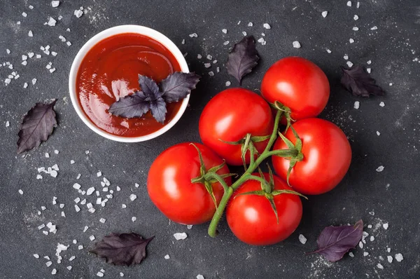 Salsa de ketchup de tomate en un bol con albahaca, sal y tomates —  Fotos de Stock