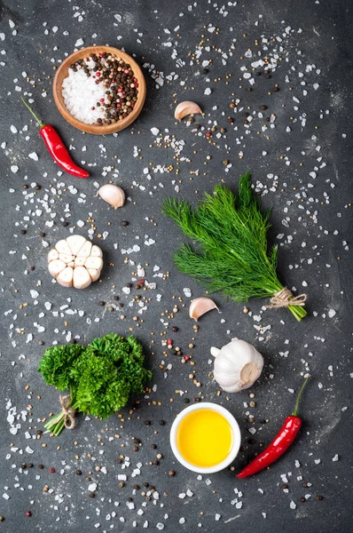 Ervas e especiarias na vista superior da mesa de pedra escura. Salsa, endro, alho, azeite e pimenta — Fotografia de Stock