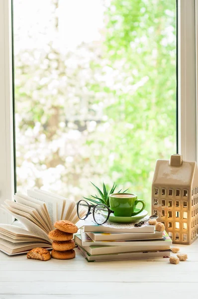 Kahve fincanı, açık kitap, gözlük, çerezler ve çiçek penceresindeki bokeh. Okuma ve kahvaltı. Kavram sıcak ve rahat ev — Stok fotoğraf