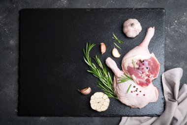 Çiğ et, biberiye ve baharatlar ile kesme tahtası bacaklarına ördek