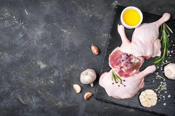 Çiğ kanatlı eti. Biberiye, baharat ve zeytinyağı koyu arka plan üzerinde kesme tahtası üzerinde ördek ayaklı — Stok fotoğraf