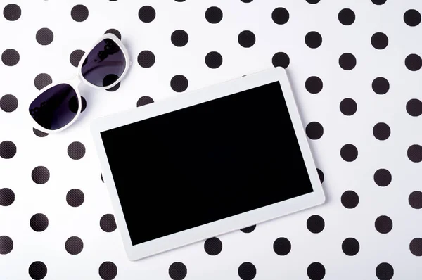 Stilize kadın Danışma tablet ile güneş gözlüğü yaratıcı arka plan en iyi görünüm düz üzerinde yatıyordu. Çalışma alanı serbest