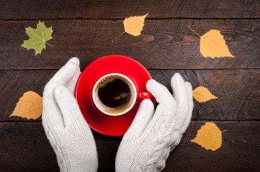 Erkek kahve fincanı ahşap tablo sonbahar yaprakları tutan eller. Sonbahar