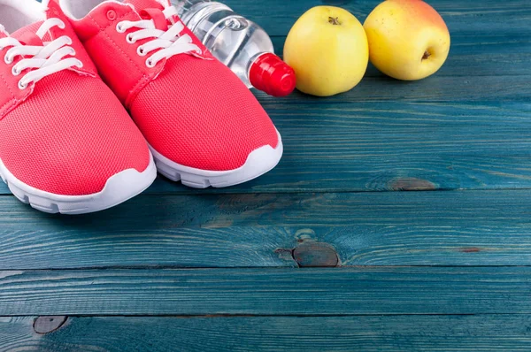 Fundo desportivo. Sapatos esportivos, água, maçãs frutas no fundo de madeira. Estilo de vida saudável, dieta, ioga, conceito de esporte — Fotografia de Stock