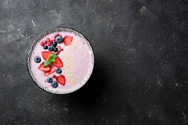 Çilek, çilek, yaban mersini, kızılcık, kuş üzümü ile smoothies kase. Pembe yüzlü. Sağlıklı yemek ve diyet kavramı. Üstten Görünüm
