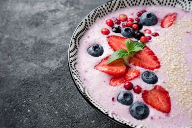 Çilek, çilek, yaban mersini, kızılcık, kuş üzümü ile smoothies kase. Pembe yüzlü portre. Sağlıklı beslenme ve diyet kavramı