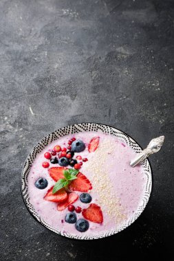 Çilek, çilek, yaban mersini, kızılcık, kuş üzümü ile smoothies kase. Pembe yüzlü. Dikey, en iyi görünümü