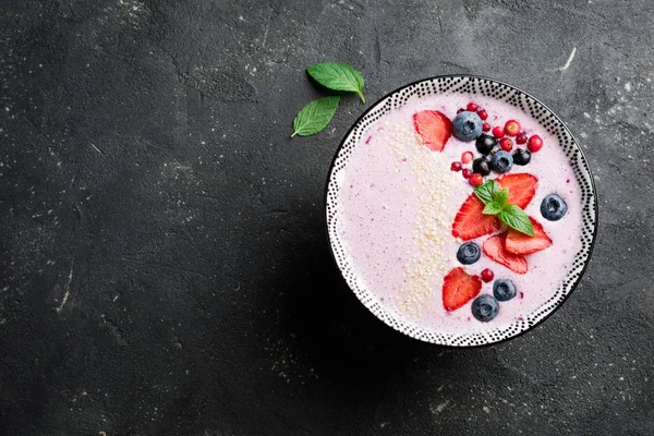 Ciotola di frullati con bacche, fragole, mirtilli, mirtilli rossi, ribes. Frullato rosa. Alimentazione sana concetto di dieta. Vista dall'alto — Foto Stock