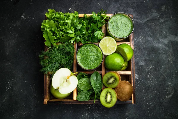 暗いコンクリートのテーブルに食材を緑のスムージー。健康的なダイエット スムージー カクテルの果物と野菜 — ストック写真