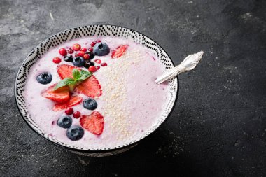 Çilek, çilek, yaban mersini, kızılcık, kuş üzümü ile smoothies kase. Pembe yüzlü portre. Sağlıklı beslenme ve diyet kavramı