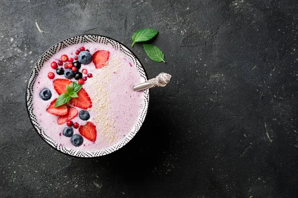 Smoothies bowl with berries, strawberries, blueberries, cranberries, currants. Pink smoothie. Healthy eat and diet concept. Top view