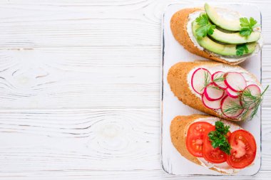 Krem peynir, sebze ve avokado ile Mini sandviç. Sandviç beyaz arka plan, üstten görünüm üzerinde çeşitli. Düz yatıyordu