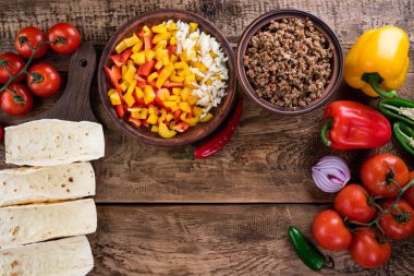 Meksika yemek sebze ve et ile. Madde tacos al papazı ahşap arka plan üzerinde yemek pişirmek için. Üstten Görünüm