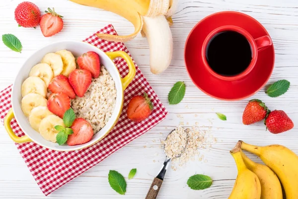 Yulaf lapası meyve ve çilek ile ile kahvaltı. Kahve fincanı. Çilek ve muz yulaf ezmesi. Sağlıklı kahvaltı konsepti