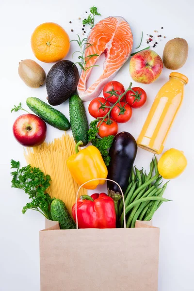 Hälsosamt ätande bakgrund. Hälsosam mat i full papperspåse med fisk, grönsaker och frukter på vitt. Måltiden planering koncept — Stockfoto