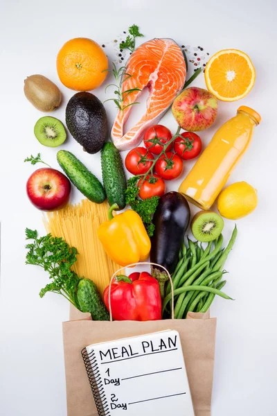 Здоровое питание. Здоровое питание в бумажном пакете с рыбой, овощами и фруктами на белом. Концепция планирования питания — стоковое фото