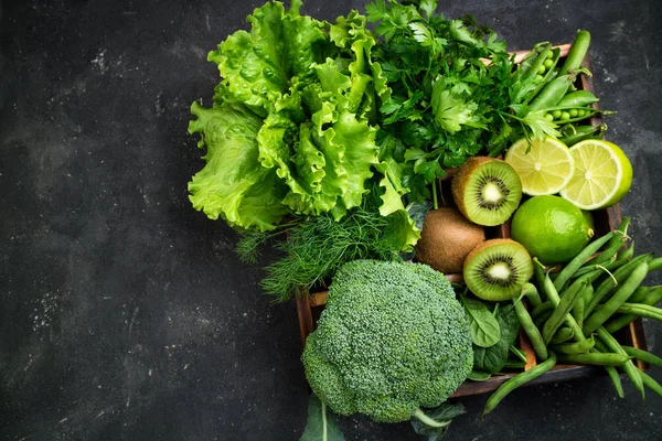 Legumes verdes. Brócolis, espinafre, kiwi, alface, salsa, endro, feijão espargos em mesa de concreto escuro. Comida vegetariana — Fotografia de Stock