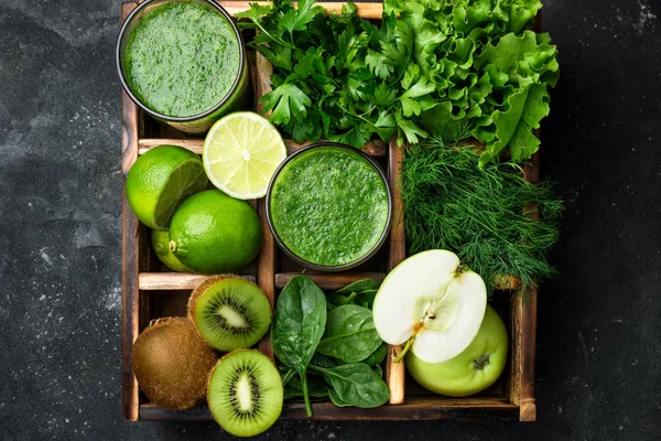 Batido verde con ingredientes sobre mesa de hormigón oscuro. Cóctel de batido saludable con frutas, verduras y hierbas. Concepto de alimentación saludable y dieta — Foto de Stock