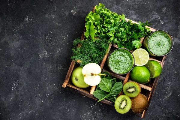 Batido verde con ingredientes sobre mesa de hormigón oscuro. Cóctel de batido saludable con frutas, verduras y hierbas. Concepto de alimentación saludable y dieta — Foto de Stock