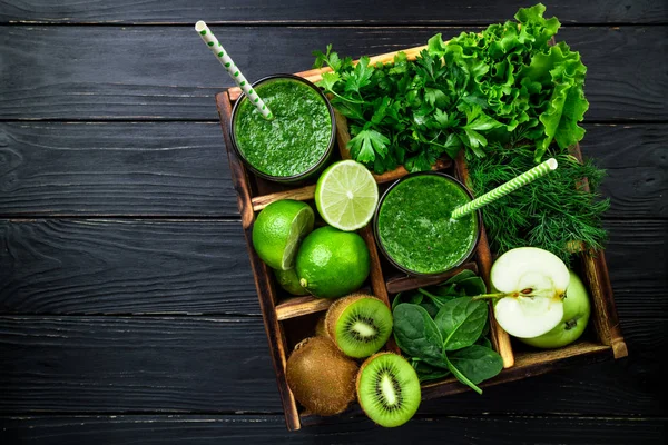 Groene smoothie op donkere houten achtergrond. Gezonde smoothie kruiden cocktail. Groene groenten en fruit. Gezonde voeding en dieet concept. Bovenaanzicht — Stockfoto