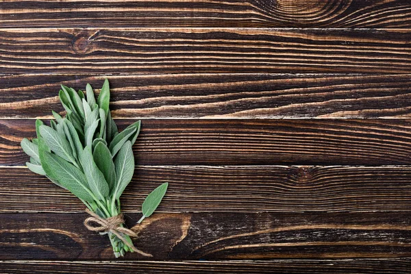 Salvia fresca su vecchio sfondo di legno. Un mazzo aromatico di salvia. Erbe da giardino — Foto Stock