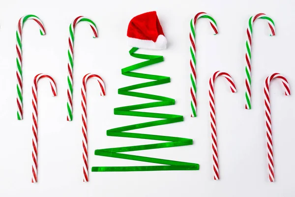 Christmas background with christmas tree made from ribbon, decorations and candy canes. Top view — Stock Photo, Image