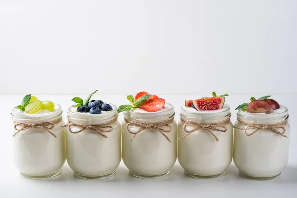 Iogurte fresco com bagas em jarros de vidro. Alimentação saudável, dieta e conceito de pequeno-almoço — Fotografia de Stock