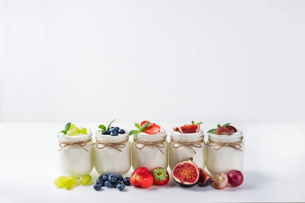 Yogurt fresco con bacche in barattoli di vetro. Cibo sano, dieta e concetto di colazione — Foto Stock