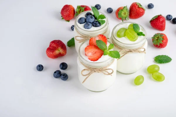 Yogurt fresco con bacche in barattoli di vetro. Prodotti lattiero-caseari. Cibo sano, dieta e concetto di colazione — Foto Stock