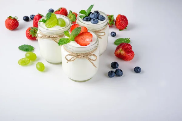 Frisse yoghurt met bessen in glazen potten. Zuivelproducten. Gezonde voeding, dieet en ontbijt concept — Stockfoto