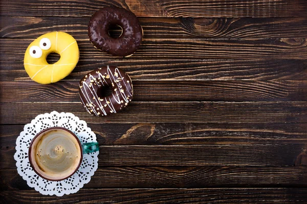 Кофейная чашка и пончики на деревянном столе. Завтрак. Вид сверху — стоковое фото