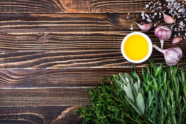 Erbe e spezie fresche, aglio, olio d'oliva su fondo di legno. Cibo sano e concetto di cucina. Erbe da giardino — Foto Stock