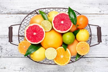 Narenciye arka plan. Yaprakları ile çeşitli taze narenciye meyve. Meyve sepeti portakal, greyfurt, limon, limon, mandalina