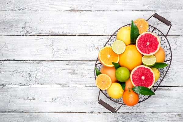 Citrus fruits background. Fruits in basket orange, grapefruit, lemon, lime, tangerine. Assorted fresh citrus fruits with leaves. Top view — Stock Photo, Image