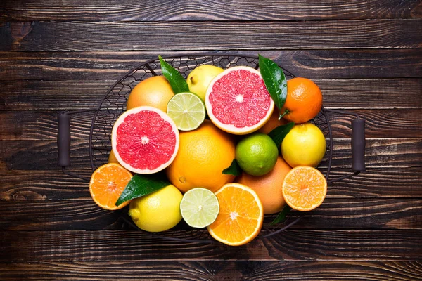 Citrus fruits background. Fruits in basket orange, grapefruit, lemon, lime, tangerine. Assorted fresh citrus fruits with leaves — Stock Photo, Image