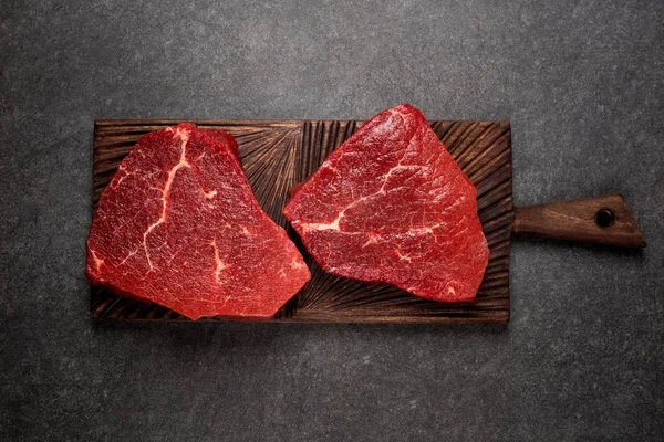 Rauw vlees, biefstuk op donkere achtergrond, bovenaanzicht — Stockfoto