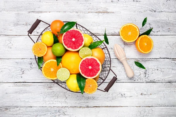 Frutas cítricas e fundo de suco de cítricos de cozinha. Frutos cítricos frescos variados com folhas. Laranja, toranja, limão, limão, tangerina — Fotografia de Stock