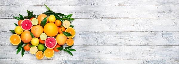 Fresh citrus fruits background. Orange, grapefruit, lemon, lime, tangerine. Mix citrus fruits with leaves. Long web format for banner — Stock Photo, Image