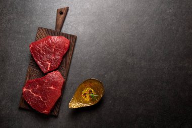 Kesme tahtası otlar ve baharatlar ile mermer ham sığır eti biftek