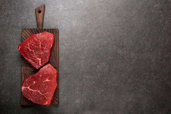 Raw marbled meat Steak ribeye on dark background. Angus meat